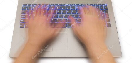 Tecnico che controlla un PC desktop e un notebook su un banco di lavoro