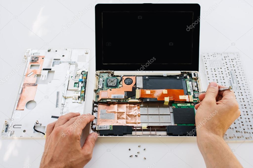 Tecnico che ripara un computer desktop aperto sul banco di lavoro